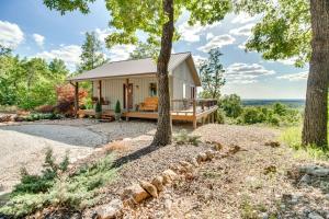 a home in the woods with a wrap around porch at Mountain Home Cabin Rental with Fire Pit! in Mountain Home