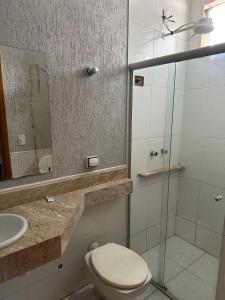 La salle de bains est pourvue de toilettes, d'un lavabo et d'un miroir. dans l'établissement Hotel Vitrine, à Goiânia