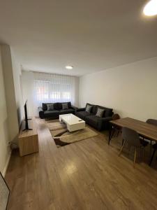 a living room with a couch and a table at White Downtown Apartment in Ferizaj