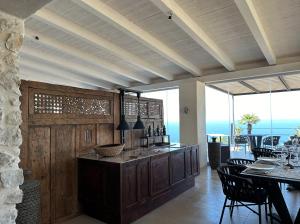 a dining room with a bar and a table with chairs at Baglio La Porta by Geocharme in San Vito lo Capo
