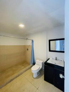 a bathroom with a toilet and a sink at Gorgona Beach House in Nueva Gorgona