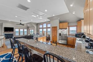 a kitchen with a large island with bar stools at 7042 - Whistling Oyster by Resort Realty in Rodanthe
