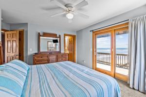a bedroom with a bed and a view of the ocean at 7042 - Whistling Oyster by Resort Realty in Rodanthe