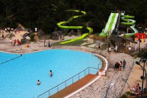 un parco acquatico con scivolo e persone di ARconciergerie Évasion en Pleine Nature a Boigneville