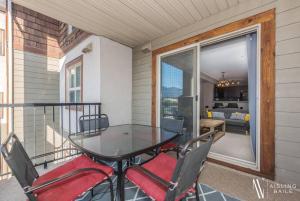 a balcony with a table and chairs on a patio at Contemporary, Cozy, Pool, Hot Tub, Lake Front in Invermere