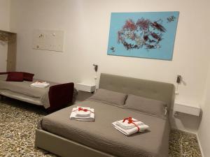 una camera con due letti con fiocchi rossi sopra di Rossocorallo Rooms ad Alghero
