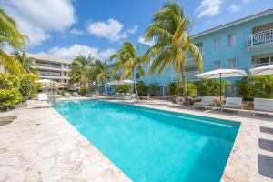 basen przed hotelem z palmami w obiekcie Dolphin Suites & Wellness Curacao w mieście Willemstad