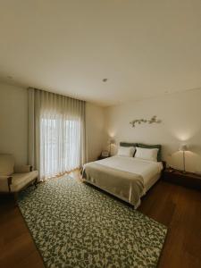 a bedroom with a large bed and a rug at Refúgio da Rainha in Moledo +61 photos
