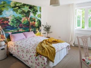 um quarto com uma cama com um quadro na parede em The Nest em Surfleet