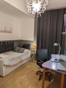 a bedroom with a bed and a desk with a laptop at Alma Vacation Apartment in the centre, big terrace in Milan