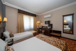a hotel room with two beds and a mirror at Pera Rose Hotel - Taksim Pera in Istanbul