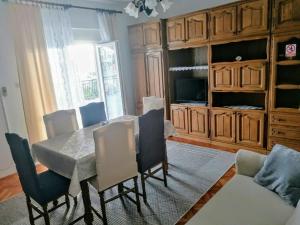 a dining room with a table and chairs and a couch at Apartman TRALJE in Senj