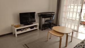 un soggiorno con televisione, tavolo e sedie di Almichara a El Médano