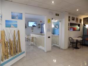 Hostal Villa Maruja في إل أرينال: غرفة مع حوض استحمام وطاولة وكراسي