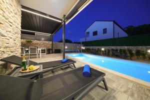 a villa with a swimming pool at night at Holiday house ZOROO with private pool in Sveti Anton