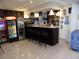 a bar in a store with bar stools and drinks at Hostal Villa Maruja in El Arenal