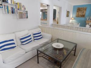 Hostal Villa Maruja في إل أرينال: غرفة معيشة مع أريكة بيضاء وطاولة
