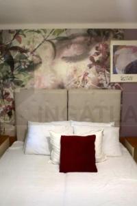 a white bed with a painting on the wall at D6 apartment in Szeged