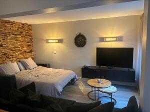 a bedroom with a bed and a flat screen tv at L'esprit du quai in Boulogne-sur-Mer