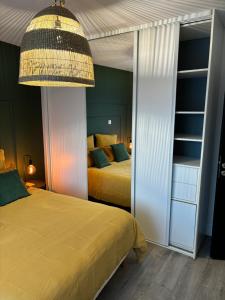 a bedroom with two beds and a chandelier at L'esprit du quai in Boulogne-sur-Mer