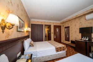 Pera Rose Hotel & Spa - Taksim Pera في إسطنبول: غرفه فندقيه سريرين وتلفزيون