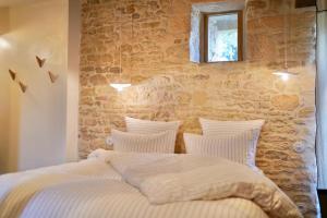 - une chambre avec un lit et un mur en pierre dans l'établissement Maison Lou Piade, à Sarlat-la-Canéda