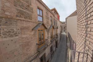 un callejón estrecho en un viejo edificio de ladrillo en Nuñez de Arce en Toledo