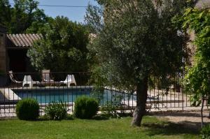 a swimming pool with a tree in a yard at Ferme St Pierre gîte autonome 2-4 personnes in Chabeuil