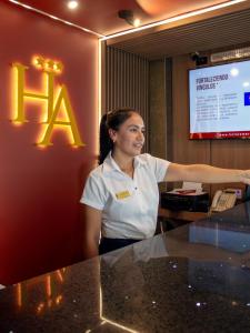 a woman standing at a counter in a hotel room at Hotel America Chiclayo in Chiclayo