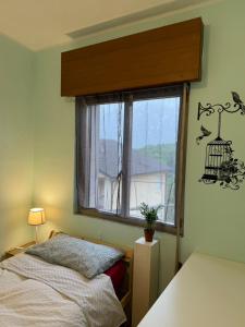 1 dormitorio con 1 cama y una ventana con una jaula de pájaro en la pared en B&B il riccio, en Paspardo