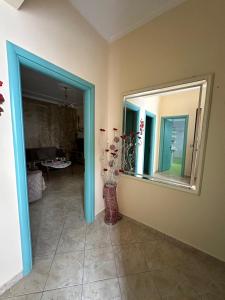 a room with a mirror and a vase with flowers at Joen Apartment 3 in Sarandë +5 photos
