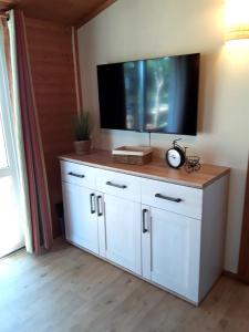 a flat screen tv on top of a white cabinet at Cap d'Agde chalet vue sur la mer in Agde