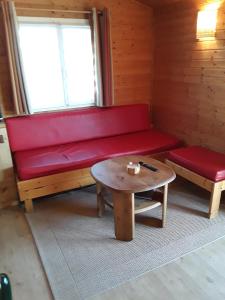 a red couch and a coffee table in a room at Cap d'Agde chalet vue sur la mer in Agde