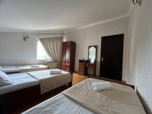a hotel room with two beds and a mirror at Guesthouse Emilya in Kutaisi