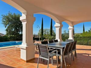 an outdoor patio with a black table and chairs at Villa Los Olivos - Ole Solutions in Arcos de la Frontera