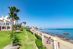 un grupo de personas caminando por la playa en PL- Beachfront seaview and frontline beach, en Mijas Costa
