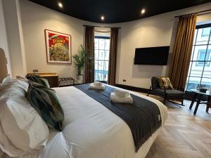 sypialnia z dużym białym łóżkiem i telewizorem z płaskim ekranem w obiekcie Crescent Place w mieście Cheltenham