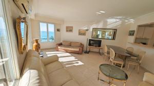 a living room with a couch and a table at Ref ILES - Palmes d'Or Properties in Cannes
