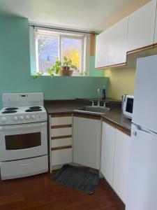 a kitchen with a white stove and a sink at Ozone Homes-Private Basement Unit in Halifax
