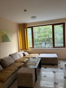 a living room with a couch and a large window at Студио Бургас 2 in Burgas