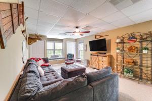 a living room with a large couch and a flat screen tv at 9 Mi to Sugar Mountain Newland Cabin with Fire Pit! in Newland