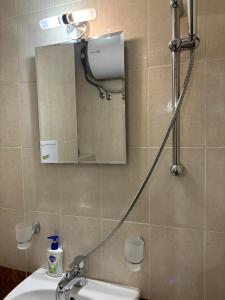 a bathroom with a shower with a mirror and a sink at Студио Бургас 2 in Burgas