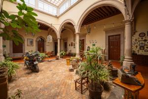 デュランゴにあるHotel Posada San Agustinの植物とオートバイが並ぶ広い部屋