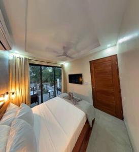 een slaapkamer met 2 witte bedden en een raam bij Villas Luna Africana by Palmer in Puerto Viejo