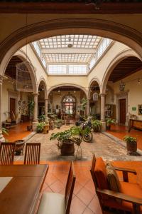 een grote kamer met tafels en stoelen en potplanten bij Hotel Posada San Agustin in Durango
