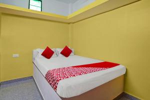 um quarto com uma cama com almofadas vermelhas em Super OYO Flagship M Adarsh Guest House em Patna