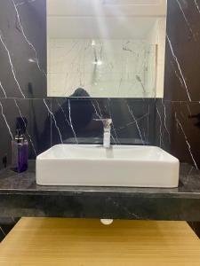 a white sink in a bathroom with a mirror at Glorious NOUACEUR in Nouaceur