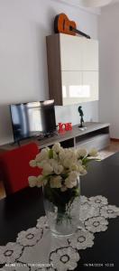 a vase of flowers on a table in a living room at LoVe House - Apartment on the beach in Pescara