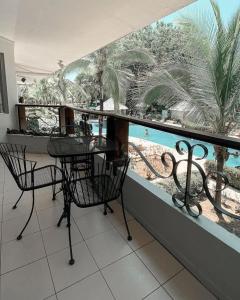 einen Balkon mit einem Tisch, Stühlen und einem Pool in der Unterkunft Poolside Oasis near Manuel Antonio! AC/WiFi/Tennis in Quepos