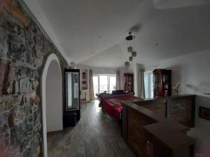 a living room with a bed and a stone wall at Apartment Trieste M&M in Muggia +65 photos